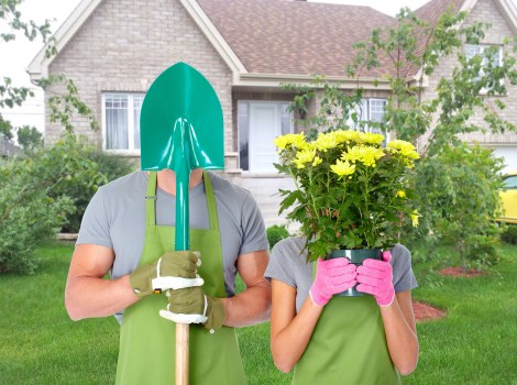 Garden operative wearing protective clothing using a hedge trimmer